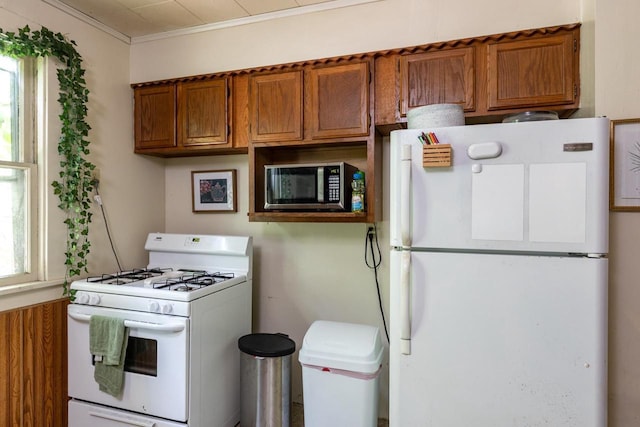 863 Jackson St, Oshkosh, WI 54901 - kitchen with white appliances, brown cabinets, and ornamental molding