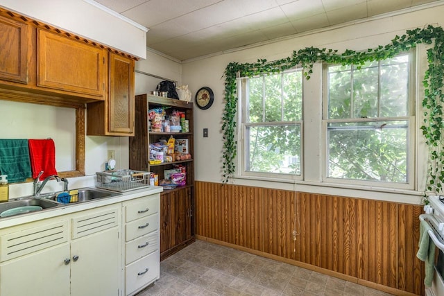 863 Jackson St, Oshkosh, WI 54901 - kitchen featuring light countertops, stove, brown cabinetry, and crown molding