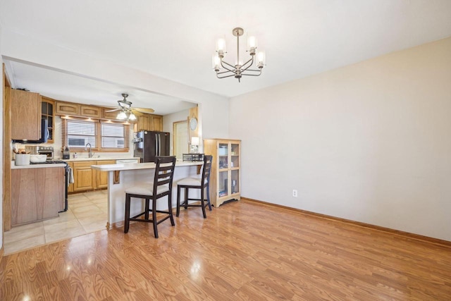 3901 Western Way, Racine, WI 53404 - kitchen featuring freestanding refrigerator, electric stove, a chandelier, light countertops, and a breakfast bar