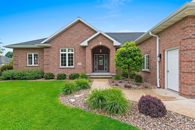 3234 W Twin Pines Ct, Green Bay, WI 54311 - view of front of home with a front lawn, brick siding, and roof with shingles