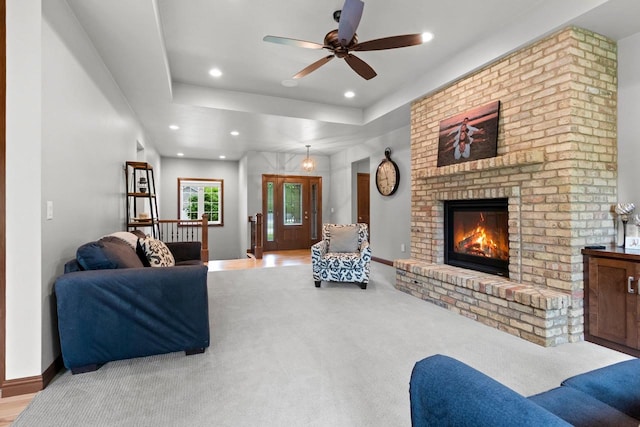 3234 W Twin Pines Ct, Green Bay, WI 54311 - carpeted living room featuring a fireplace, recessed lighting, ceiling fan, and a tray ceiling