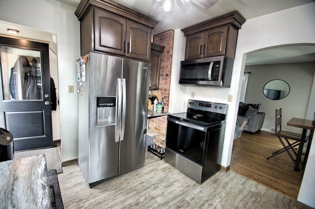 621 N Linwood Ave, Appleton, WI 54914 - kitchen featuring stainless steel appliances, dark brown cabinetry, arched walkways, light wood-style flooring, and ceiling fan
