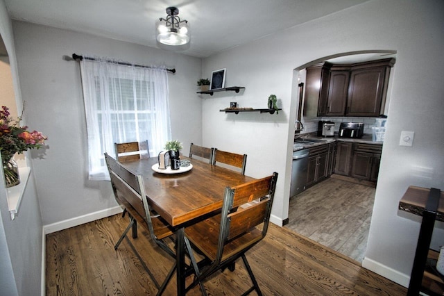621 N Linwood Ave, Appleton, WI 54914 - dining area with light wood-type flooring, arched walkways, and a chandelier