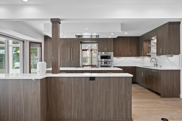 6834 S 35th St, Franklin, WI 53132 - kitchen featuring plenty of natural light, a kitchen island, light countertops, dark brown cabinetry, and recessed lighting