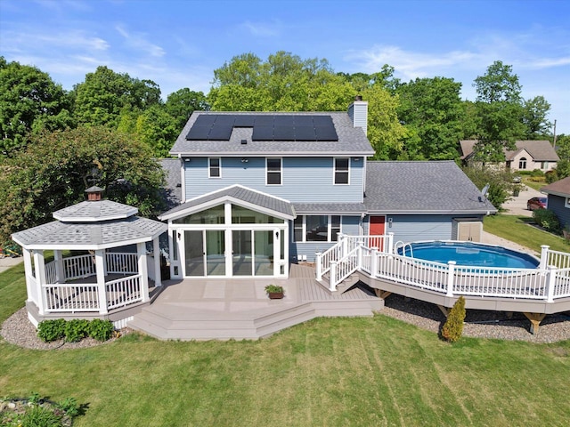 6834 S 35th St, Franklin, WI 53132 - rear view of house with a gazebo, a chimney, solar panels, a deck, and a yard