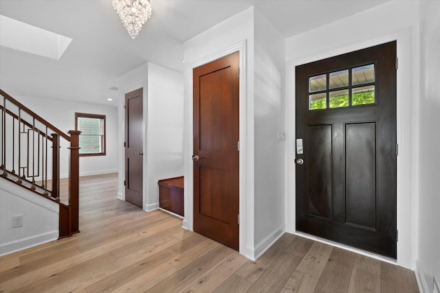 6834 S 35th St, Franklin, WI 53132 - foyer entrance with stairs, a skylight, light wood-style flooring, and a chandelier