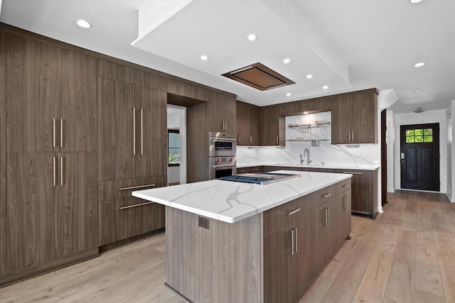 6834 S 35th St, Franklin, WI 53132 - kitchen with light wood-style floors, decorative backsplash, modern cabinets, recessed lighting, and stainless steel double oven