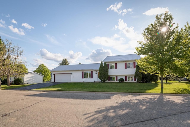 123 Westgate Dr, Iron Ridge, WI 53035 - tri-level home featuring asphalt driveway, a front lawn, a garage, and a metal roof