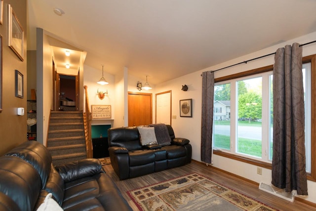 123 Westgate Dr, Iron Ridge, WI 53035 - living room featuring healthy amount of natural light, wood finished floors, vaulted ceiling, and stairway