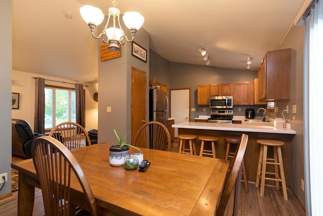123 Westgate Dr, Iron Ridge, WI 53035 - dining room featuring vaulted ceiling, a chandelier, and dark wood-style flooring