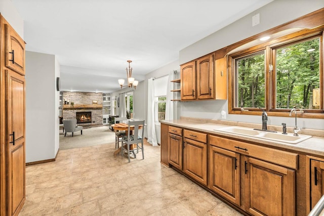 2311 Maplewood Dr, Plover, WI 54467 - kitchen with plenty of natural light, a fireplace, brown cabinets, and light countertops