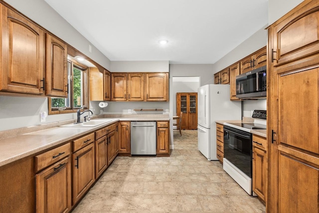2311 Maplewood Dr, Plover, WI 54467 - kitchen featuring appliances with stainless steel finishes, brown cabinets, light countertops, and stone finish floors