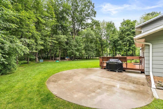 2311 Maplewood Dr, Plover, WI 54467 - view of green lawn with a patio, a deck, and view of wooded area