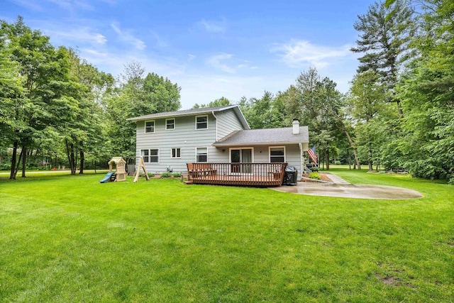 2311 Maplewood Dr, Plover, WI 54467 - back of property with a chimney, a playground, a wooden deck, and a lawn