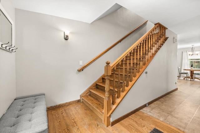 2311 Maplewood Dr, Plover, WI 54467 - stairs featuring a chandelier and wood finished floors