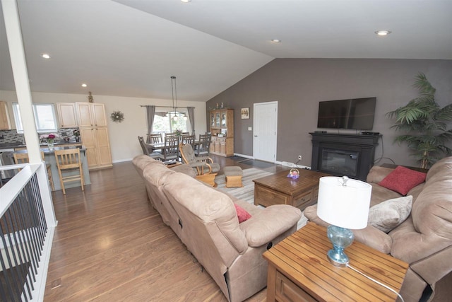 708 Owl Ln, Stevens Point, WI 54482 - living area with vaulted ceiling, light wood finished floors, recessed lighting, and a glass covered fireplace