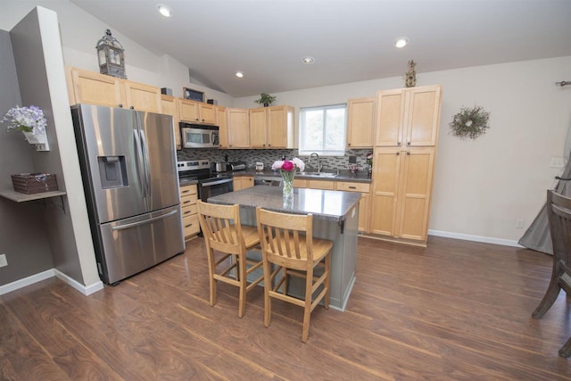 708 Owl Ln, Stevens Point, WI 54482 - kitchen with stainless steel appliances, light brown cabinetry, lofted ceiling, tasteful backsplash, and dark wood-style flooring