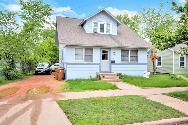1208 Wisconsin St, Stevens Point, WI 54481 - bungalow-style house with a shingled roof, a front lawn, and driveway