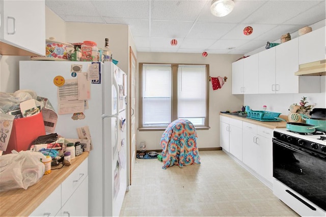 1208 Wisconsin St, Stevens Point, WI 54481 - kitchen with gas stove, a paneled ceiling, light countertops, freestanding refrigerator, and light flooring