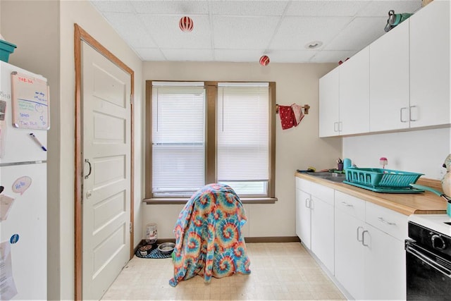 1208 Wisconsin St, Stevens Point, WI 54481 - kitchen featuring a drop ceiling, freestanding refrigerator, light countertops, electric range oven, and white cabinetry