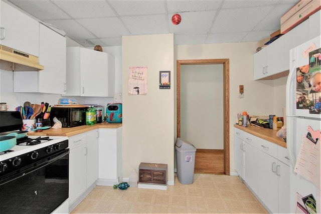1208 Wisconsin St, Stevens Point, WI 54481 - kitchen featuring gas range oven, freestanding refrigerator, under cabinet range hood, a drop ceiling, and light countertops