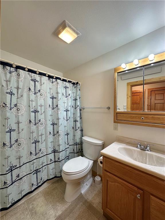 4686 W Butler Rd, Winter, WI 54896 - full bath with vanity, tile patterned floors, and a shower with shower curtain