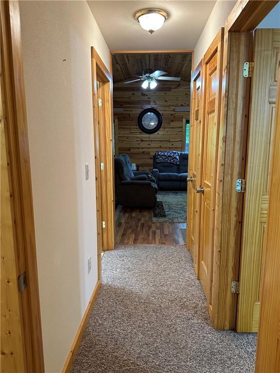 4686 W Butler Rd, Winter, WI 54896 - hallway with wooden walls and carpet floors
