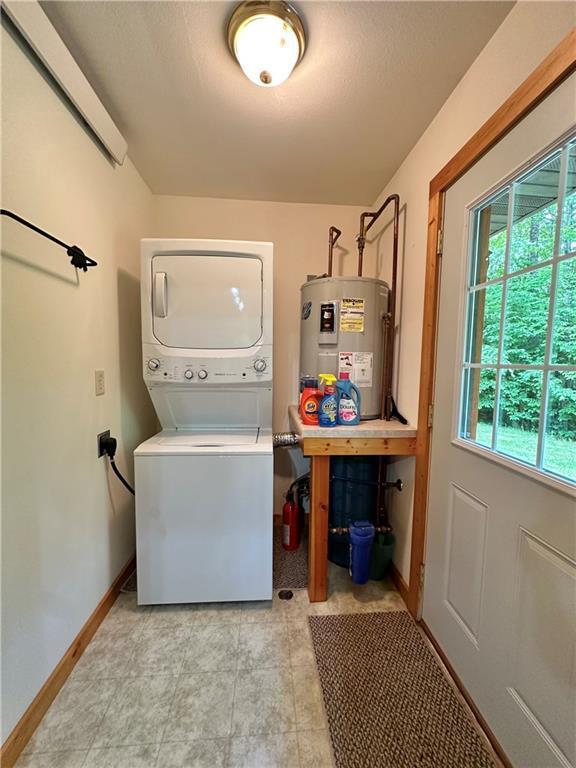 4686 W Butler Rd, Winter, WI 54896 - laundry room featuring water heater, stacked washer / drying machine, and healthy amount of natural light
