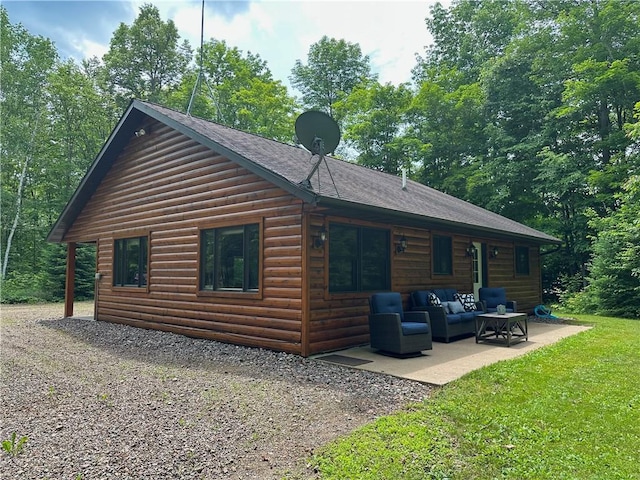 4686 W Butler Rd, Winter, WI 54896 - view of property exterior with faux log siding, an outdoor living space, a patio, and a shingled roof