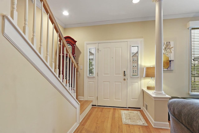 413 56th St, Kenosha, WI 53140 - foyer entrance featuring crown molding, light wood finished floors, ornate columns, stairs, and recessed lighting