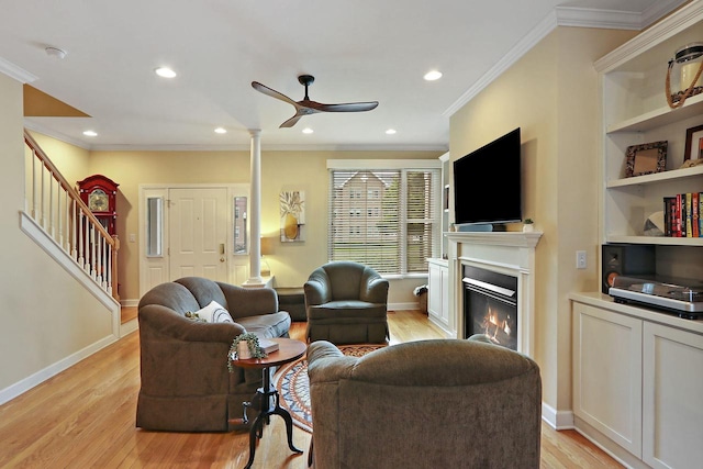 413 56th St, Kenosha, WI 53140 - living room featuring stairs, ceiling fan, light wood-style floors, a glass covered fireplace, and crown molding