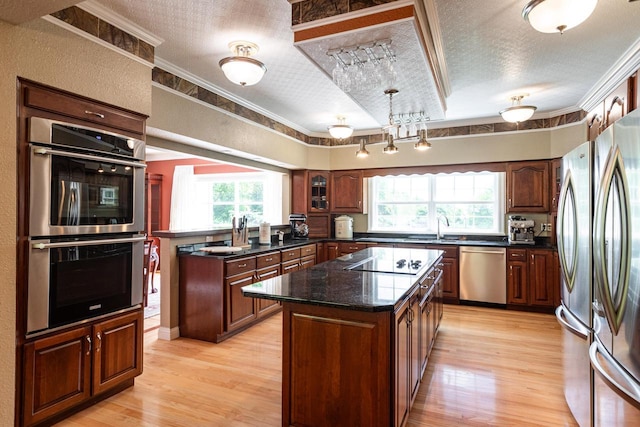 N2194 Valley Rd, La Crosse, WI 54601 - kitchen with stainless steel appliances, a textured ceiling, light wood-style floors, a center island, and ornamental molding