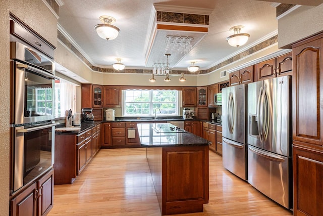 N2194 Valley Rd, La Crosse, WI 54601 - kitchen featuring appliances with stainless steel finishes, light wood finished floors, ornamental molding, a textured ceiling, and a center island