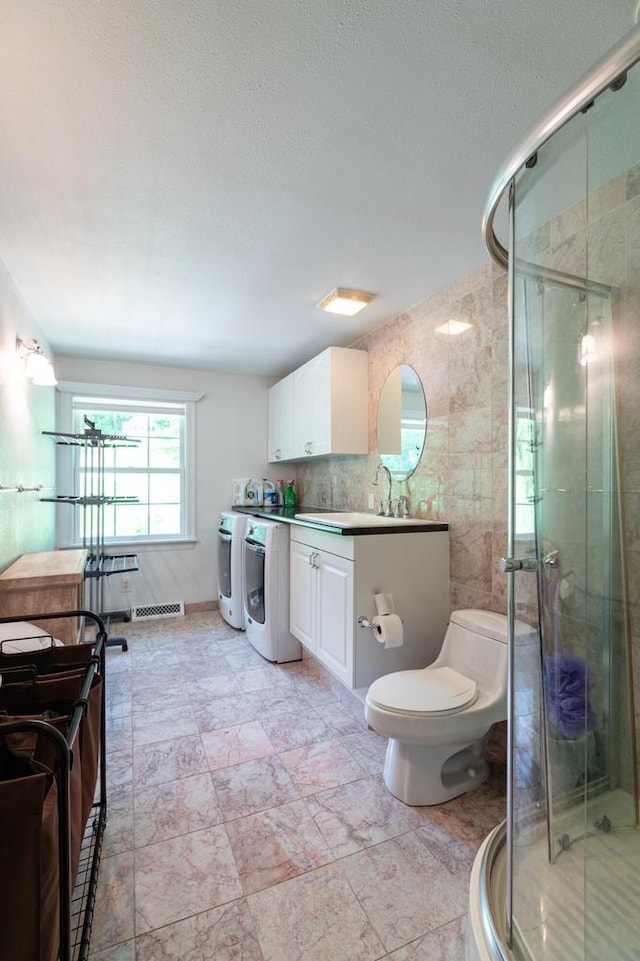 N2194 Valley Rd, La Crosse, WI 54601 - full bathroom with washer and dryer, vanity, a stall shower, and a textured ceiling