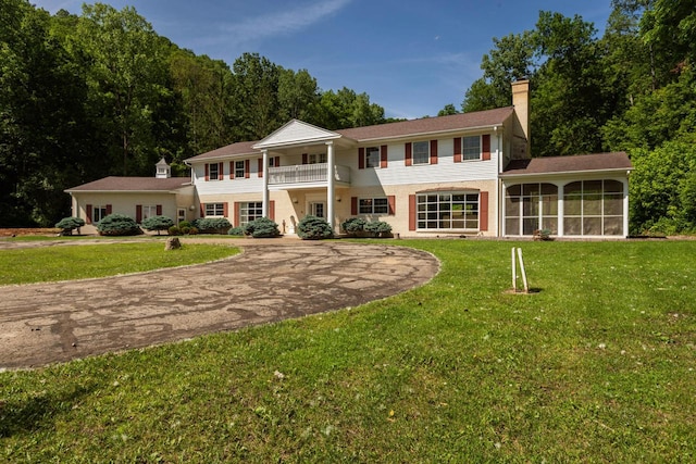 N2194 Valley Rd, La Crosse, WI 54601 - back of property featuring a chimney, a balcony, a sunroom, and a lawn