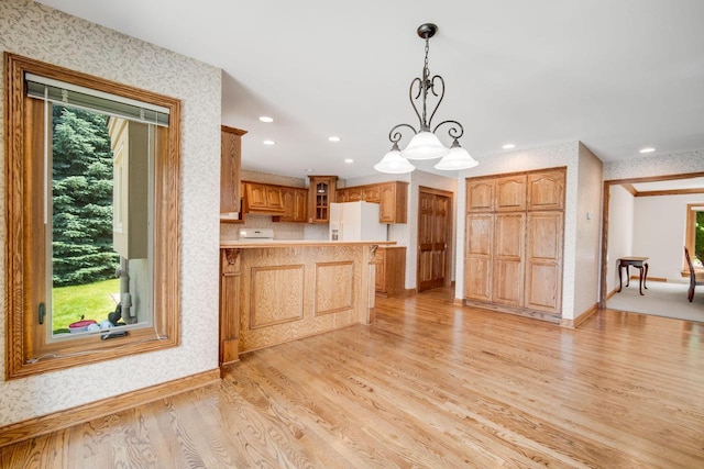 N65W38340 S Woodlake Cir, Oconomowoc, WI 53066 - kitchen with white refrigerator with ice dispenser, wallpapered walls, light wood-style floors, a peninsula, and glass insert cabinets