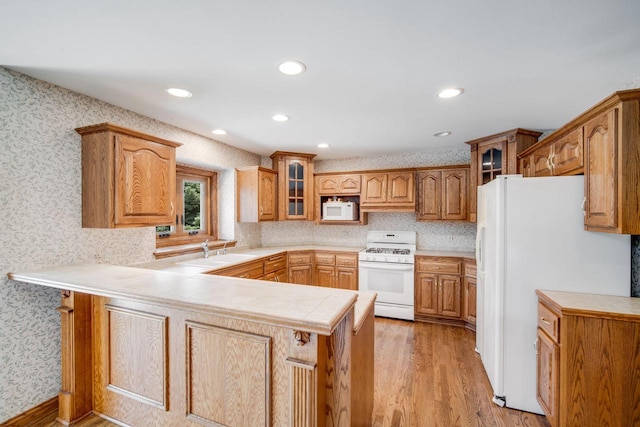 N65W38340 S Woodlake Cir, Oconomowoc, WI 53066 - kitchen with white appliances, a peninsula, light wood-style flooring, glass insert cabinets, and wallpapered walls