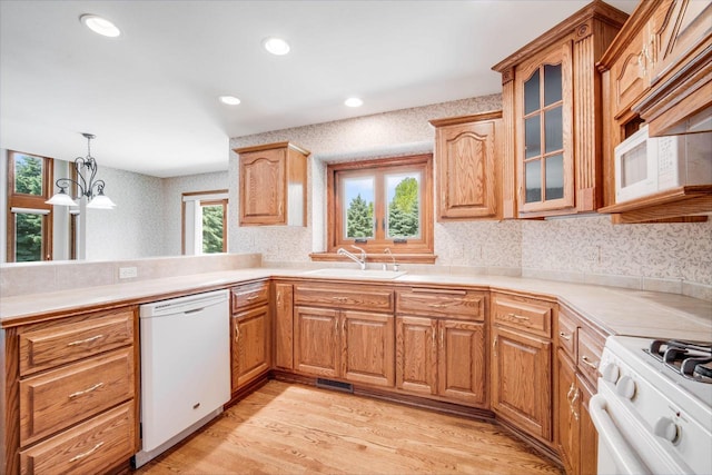 N65W38340 S Woodlake Cir, Oconomowoc, WI 53066 - kitchen featuring white appliances, a chandelier, glass insert cabinets, light wood-style flooring, and recessed lighting