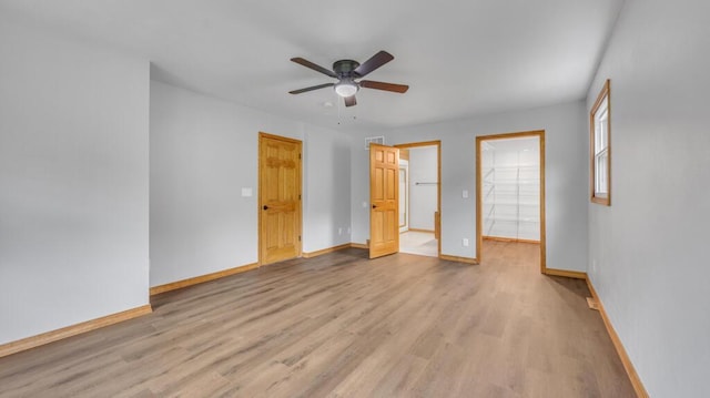 N3923 Sunny Slope Ave, Cascade, WI 53011 - unfurnished bedroom featuring wood finished floors, a walk in closet, and a ceiling fan