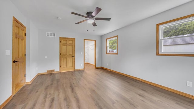 N3923 Sunny Slope Ave, Cascade, WI 53011 - unfurnished bedroom featuring light wood finished floors, a spacious closet, a ceiling fan, and a closet
