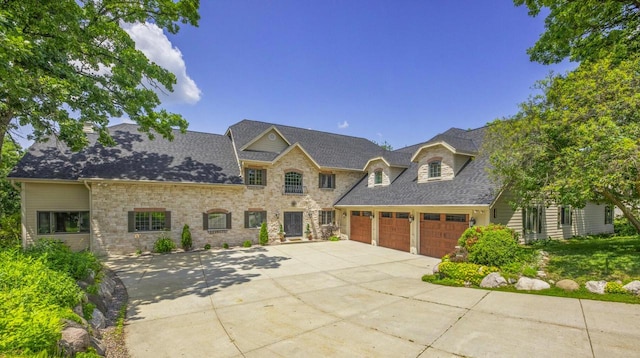 205 Kummrow Ct, Wales, WI 53183 - french country style house featuring concrete driveway, an attached garage, and a shingled roof