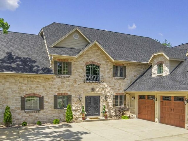 205 Kummrow Ct, Wales, WI 53183 - french provincial home with a shingled roof, stone siding, and concrete driveway