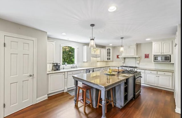 205 Kummrow Ct, Wales, WI 53183 - kitchen with stainless steel appliances, a kitchen island, white cabinetry, recessed lighting, and a kitchen bar