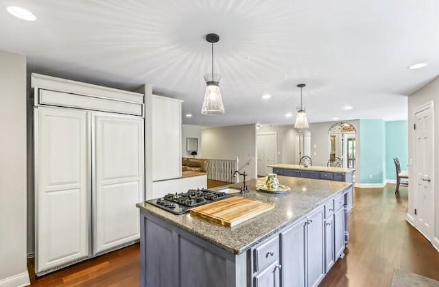 205 Kummrow Ct, Wales, WI 53183 - kitchen with gas cooktop, a center island with sink, paneled refrigerator, dark wood finished floors, and recessed lighting