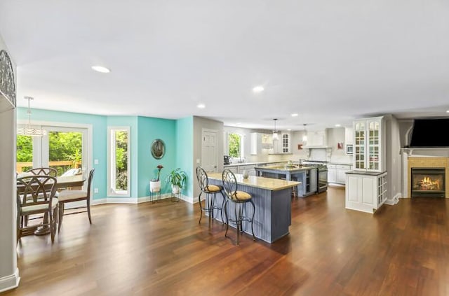 205 Kummrow Ct, Wales, WI 53183 - kitchen with recessed lighting, glass insert cabinets, a kitchen breakfast bar, dark wood-style flooring, and a spacious island