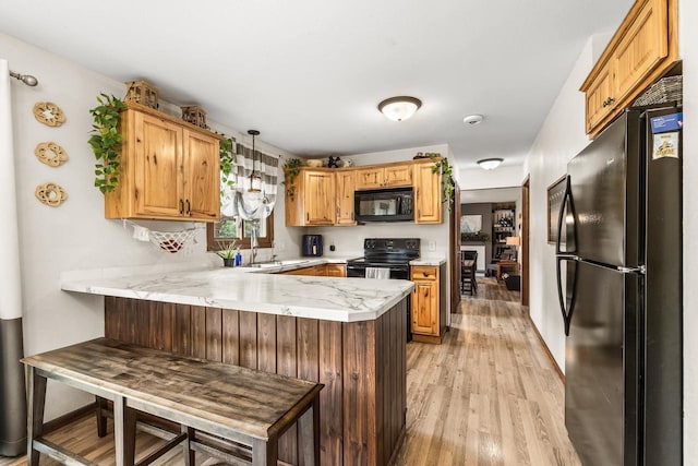 222531 Azalea Rd, Wausau, WI 54401 - kitchen with black appliances, a peninsula, light wood-type flooring, and pendant lighting