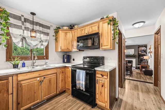 222531 Azalea Rd, Wausau, WI 54401 - kitchen featuring black appliances, light wood-type flooring, light countertops, and hanging light fixtures