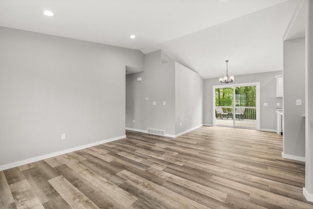 6611 Conner Davis Dr, Wausau, WI 54401 - empty room featuring lofted ceiling, light wood finished floors, a chandelier, and recessed lighting