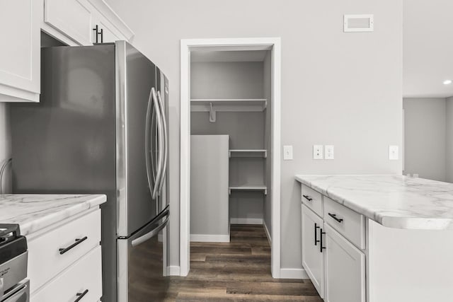 6611 Conner Davis Dr, Wausau, WI 54401 - kitchen with dark wood-type flooring, freestanding refrigerator, white cabinets, light stone countertops, and recessed lighting