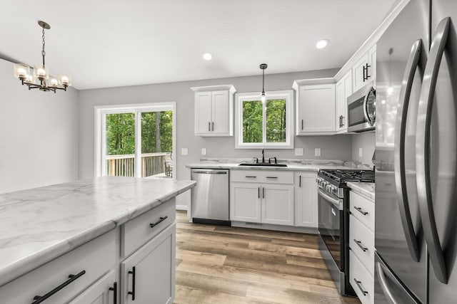 6611 Conner Davis Dr, Wausau, WI 54401 - kitchen with appliances with stainless steel finishes, a chandelier, light wood-type flooring, white cabinetry, and recessed lighting
